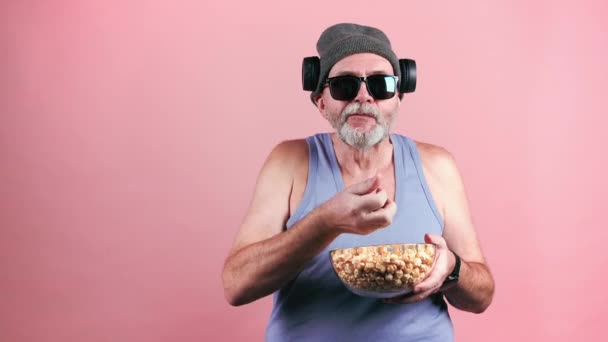 Trendi öregember popcornt eszik a tálból. - Felvétel, videó