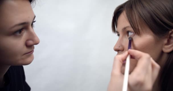 professional makeup artist applying makeup on models face before fashion show - Felvétel, videó