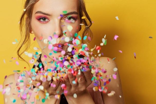 Cheerful woman and colorful confetti, party and holiday background - Foto, imagen