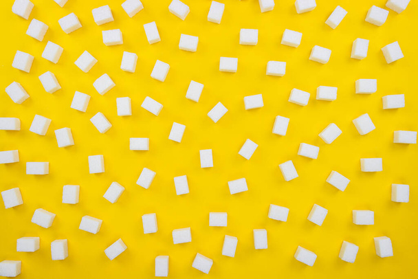 Sugar cubes on an isolated yellow background. White cubes of sugar isolated on yellow background. Sugar background flat lay. - Foto, immagini