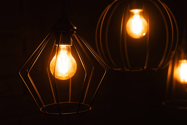 Close-up de uma lâmpada incandescente. Lâmpada com luz laranja. Queimar uma lâmpada edison incandescente com uma grande espiral decorativa
. - Foto, Imagem