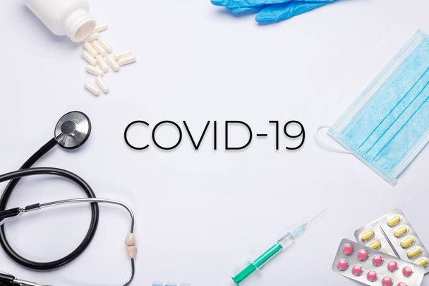 текст "CoVid-19" "на белом фоне с медицинскими вещами
. - Фото, изображение