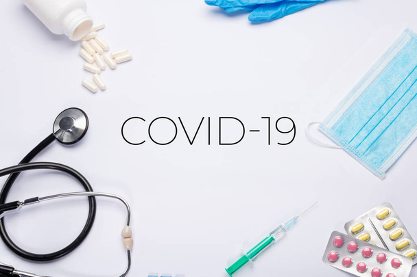 текст "CoVid-19" "на белом фоне с медицинскими вещами
. - Фото, изображение