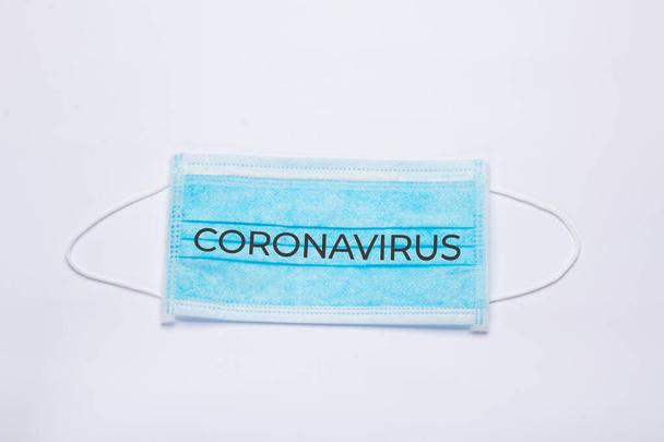"Koronavirus "text na modré lékařské masce na bílém pozadí - Fotografie, Obrázek