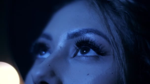 Extreme close up beautiful female eyes contemplating colorful neon lights outdoors show - Záběry, video