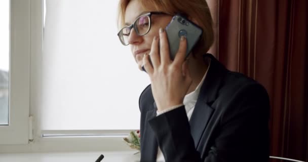 Businesswoman or accountant talking on the phone. ends the call and signs the document at office, business concept Close up - Кадри, відео
