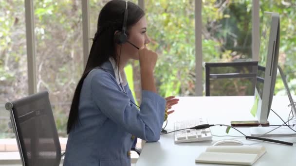 Piękny personel call center wpisuje klawiatury i rozmawia w przyjazny sposób, zapewniając uśmiechnięte usługi, dbając o obsługę. - Materiał filmowy, wideo