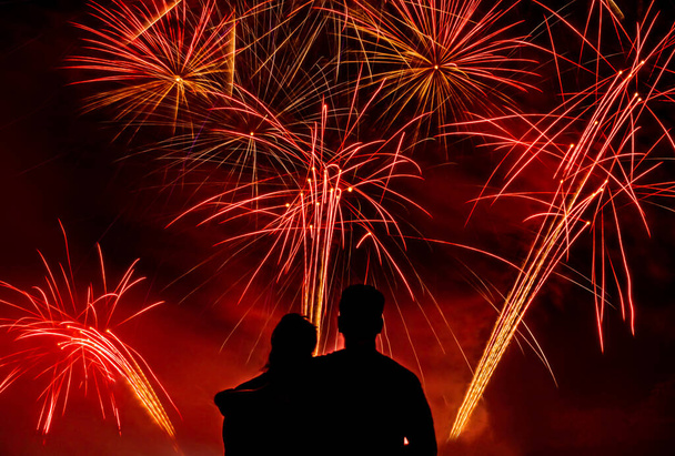 Silhouette di coppia che guarda fuochi d'artificio insieme durante giorno di indipendenza
. - Foto, immagini