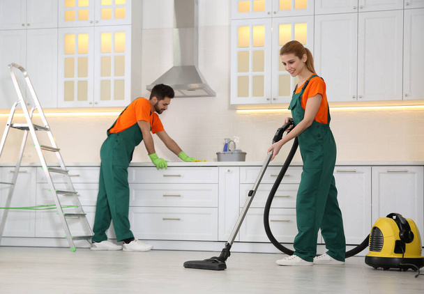 Команда профессиональных уборщиков убирает современную кухню
 - Фото, изображение