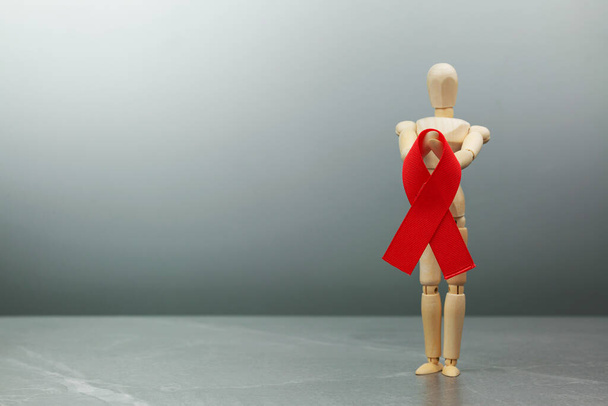 Figura de madera con cinta roja del VIH - Foto, Imagen