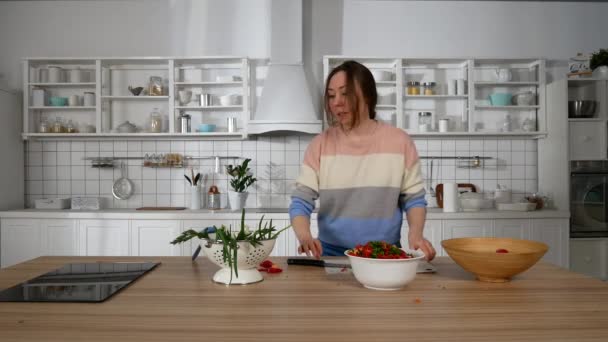 το κορίτσι στην κουζίνα ετοιμάζει μια σαλάτα - Πλάνα, βίντεο