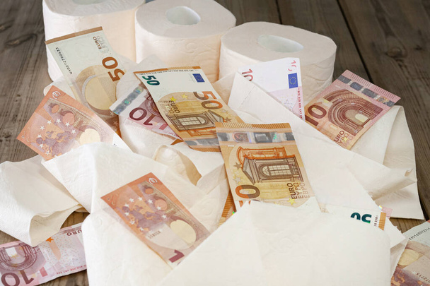 fogli e rotolo di carta igienica, euro soldi, su sfondo di legno. concetto
 - Foto, immagini