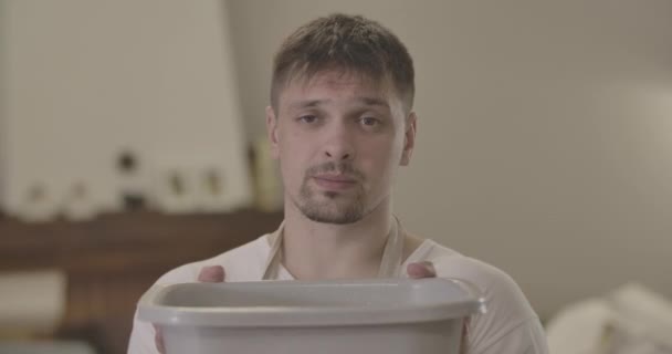 Close-up portrait of Caucasian man sighing as drops dropping from ceiling into basin. Handsome brunette guy with brown eyes having water damage at home. Repair, housekeeping. Cinema 4k ProRes HQ. - Filmati, video