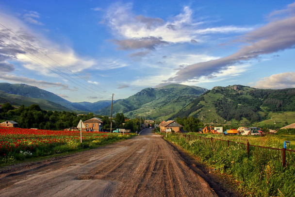 アルメニア人の村へと続く道。夕日の空と山. - 写真・画像