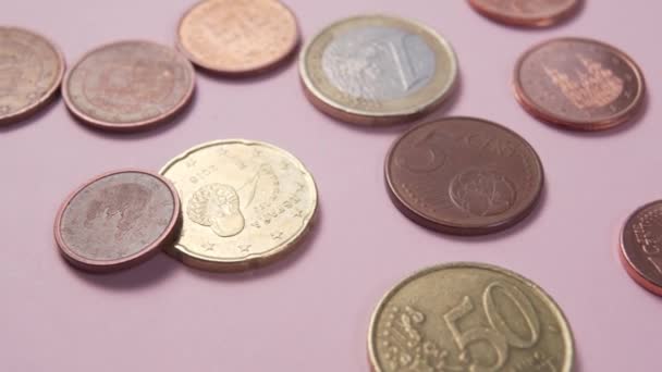 Euromince a centy se třpytí ve slunečním světle na růžovém pozadí. Makro Dolly shot - Záběry, video