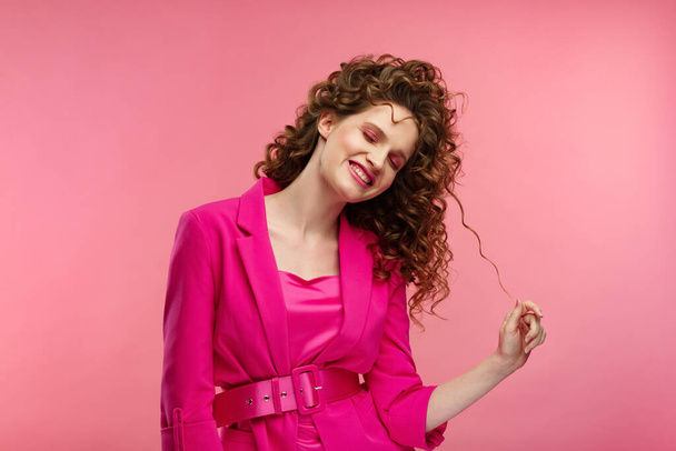 Close up fashion studio portrait of young beautiful women with curly hair.Nice girl with wavy hairstyle and bright make up isolated over pink background.Beauty and hair care concept,pink lifestyle - Photo, image