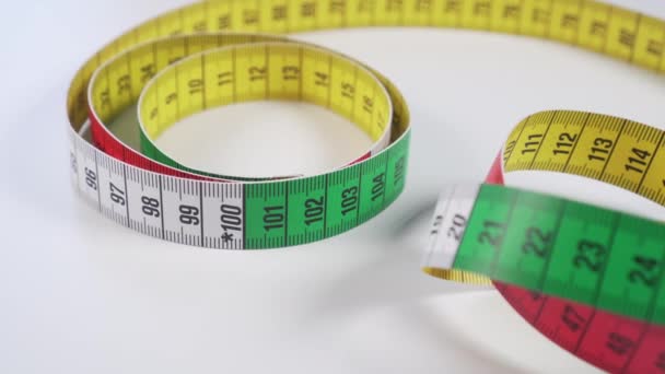 Barevný centimetr na bílém stole pro měření tělesných parametrů během stravy a pro šití oblečení - Záběry, video