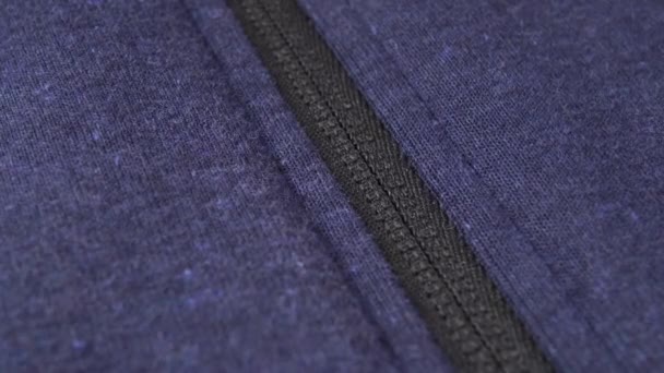 hand opens a zipper lock on a blue sports jacket. Macro shot. - Video, Çekim