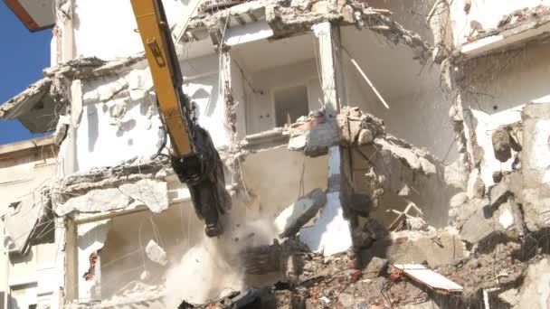 Hydraulický štěpkovač a fréza kolon bagru zadní stroj pracuje při demolici starých bytových domůbagr bourání staveniště s pracovníkem s výhledem na proces. - Záběry, video