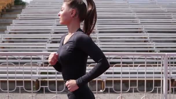 Slim woman running in city stadium - Footage, Video