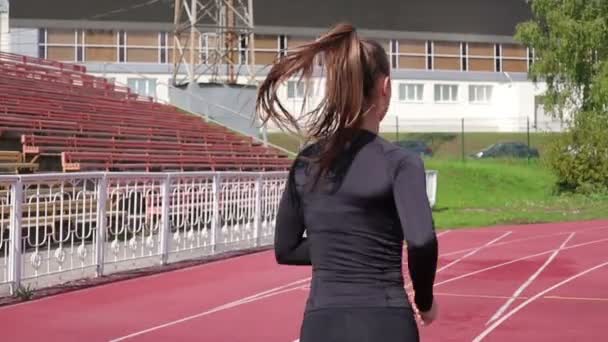 Λεπτή γυναίκα που τρέχει στην πίστα στην ηλιοφάνεια - Πλάνα, βίντεο