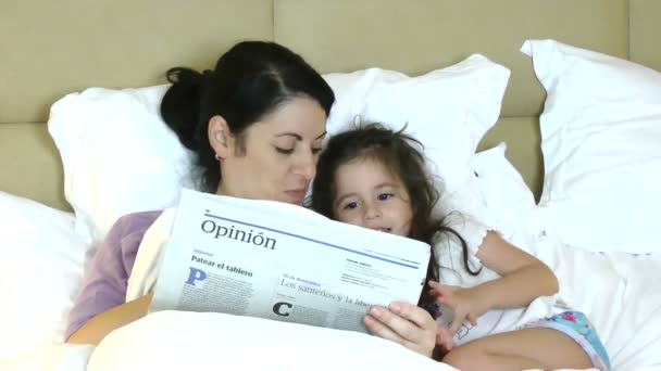 Anne ve çocuk eğleniyor yatakta gazete okuma - Video