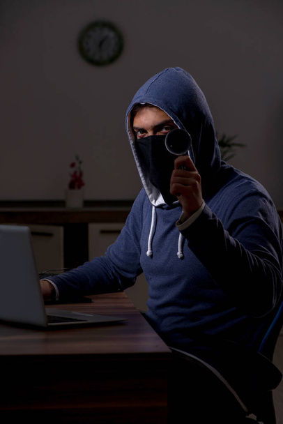 オフィスでセキュリティファイアウォールをハッキングする男性ハッカー - 写真・画像