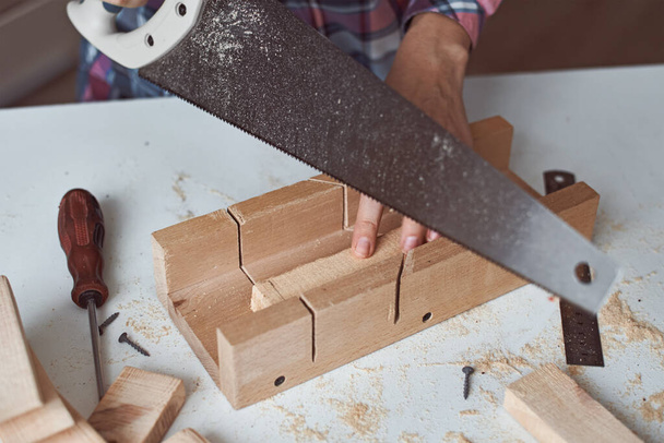 Der Prozess der Tischlerhände, die Holzbretter sägen. Konzept der Holz- und Möbelherstellung von Diy - Foto, Bild