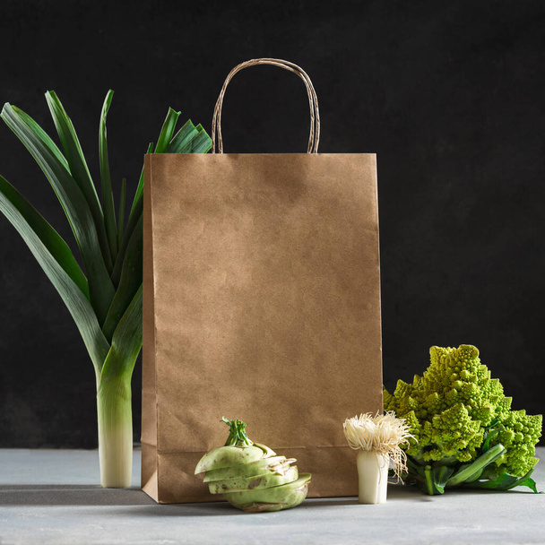 Shopping healthy food concept. Healthy food with paper bag vegetables on dark background - Fotó, kép