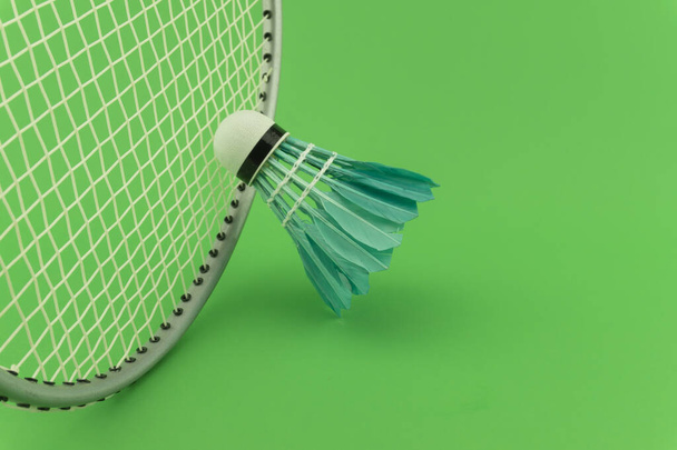 Badmintonové rakety a modré opeřené shuttlecocks na zeleném pozadí v zblízka pohled - Fotografie, Obrázek