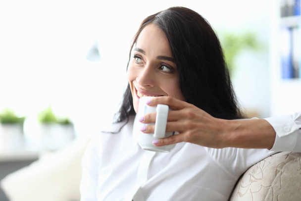 Portrait woman sitting sofa and drinking coffee - Photo, Image