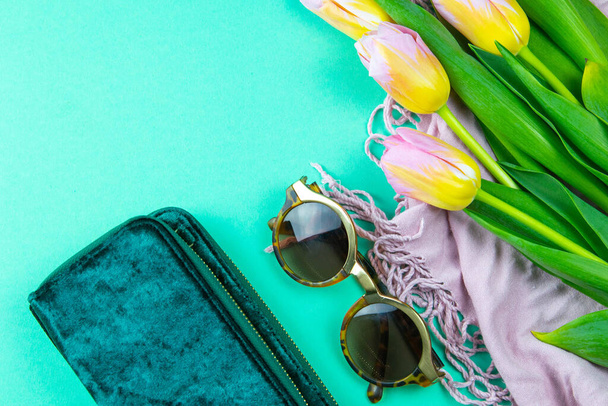 スタイリッシュな女性のハンドバッグ、眼鏡とミントの背景の春の花とフラットレイアウト組成物. - 写真・画像