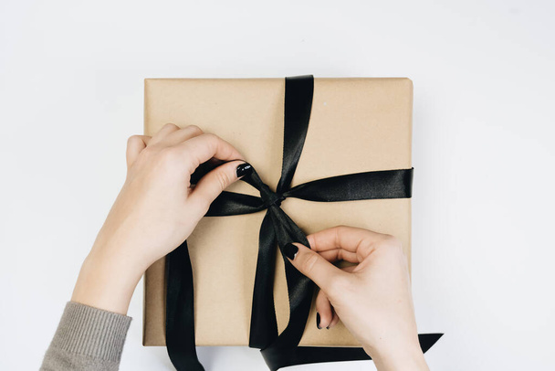 vista parcial de la mujer atando cinta en caja de regalo aislado en blanco
 - Foto, imagen