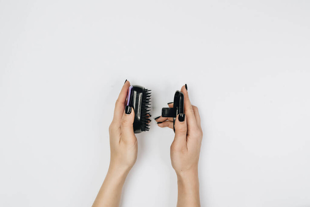 female hands holding a comb on white background - Foto, Imagen