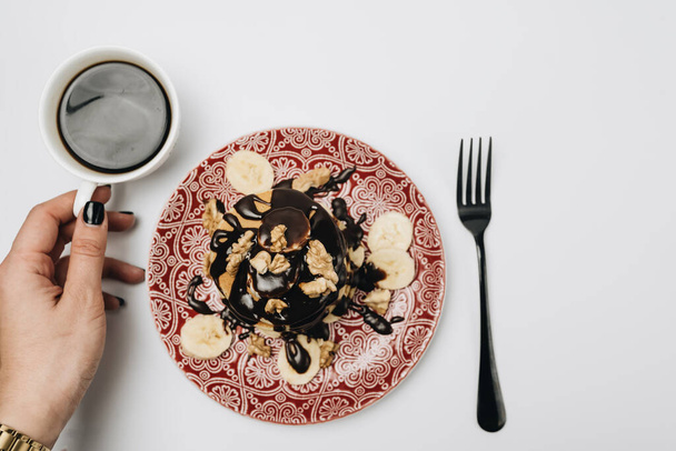 plate with cookies, chocolate topping, walnuts and sliced bananas - Photo, Image