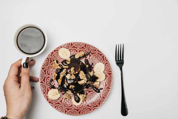 Egy halom finom házi palacsinta csokoládé öntettel, dióval és szeletelt banánnal. - Fotó, kép