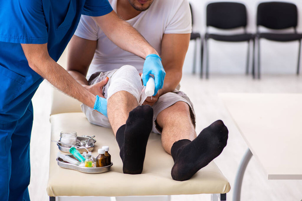 Раненый на ноге, посещение старого врача в концепции оказания первой помощи
 - Фото, изображение
