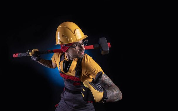 el trabajador de la construcción con un martillo de trineo
 - Foto, Imagen