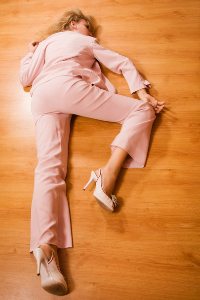 Mulher de negócios inconsciente deitada no chão
 - Foto, Imagem