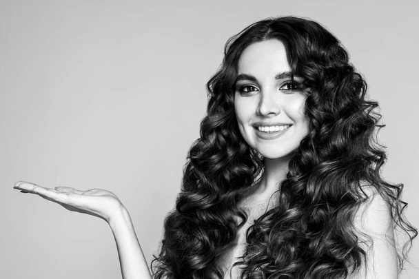 Black and white fashion portrait of a beautiful young brunette with wavy hair. - Fotó, kép