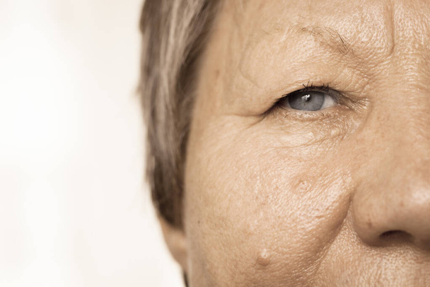 Részletek az idősebb nő fél arcát. Idős nyugdíjas női, arcát és szemét közelről. - Fotó, kép