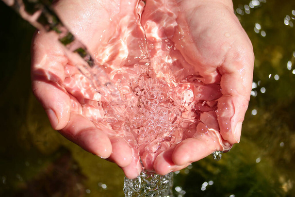natural spring water in the hands - Photo, Image