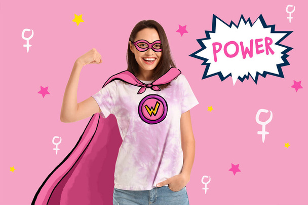 色の背景にスーパーヒーローの衣装の女性。フェミニズムの概念 - 写真・画像