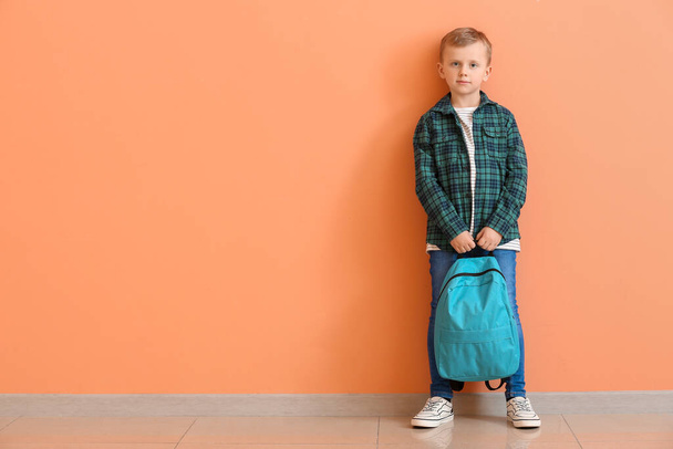Netter kleiner Junge mit Rucksack in der Nähe der Farbwand - Foto, Bild
