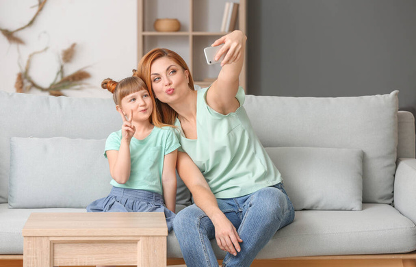 Mother and her little daughter taking selfie at home - Fotografie, Obrázek