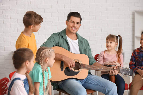 Teacher giving music lessons at school - Photo, Image