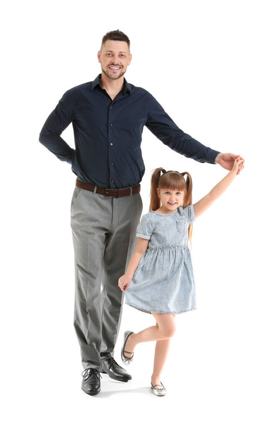 Father and his little daughter dancing against white background - Foto, afbeelding