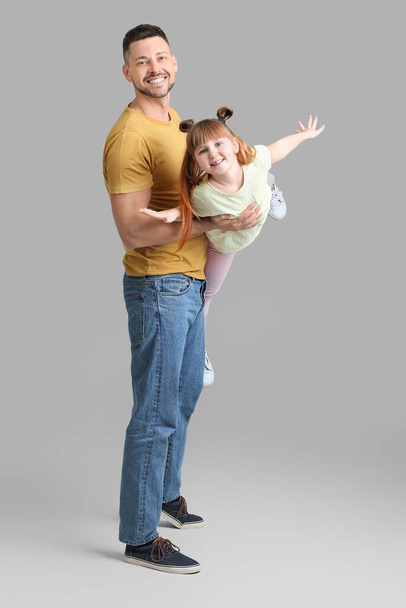 Happy father and his little daughter on grey background - Fotoğraf, Görsel