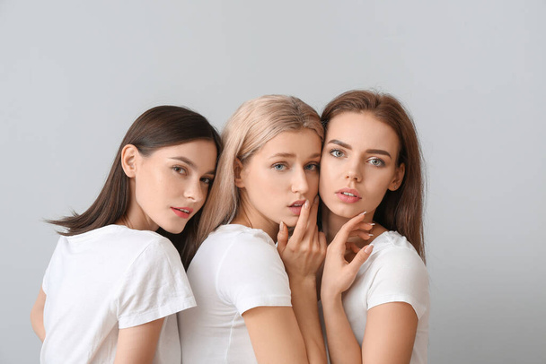 Jovens mulheres com bela maquiagem no fundo claro
 - Foto, Imagem