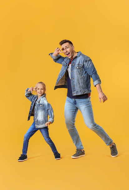 Happy man and his little daughter dancing against color background - Zdjęcie, obraz